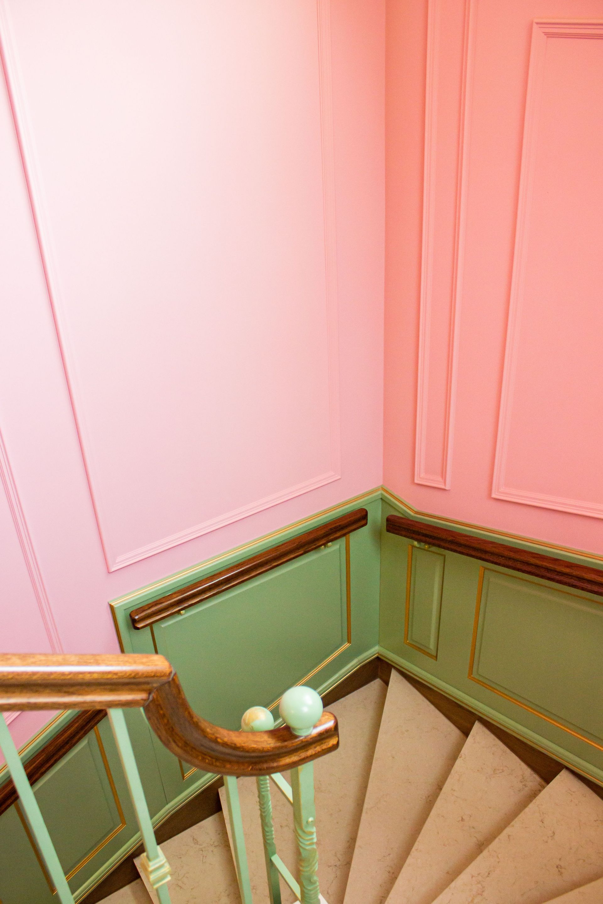 Vibrant pink and green staircase inside a building, showcasing colorful interior design.